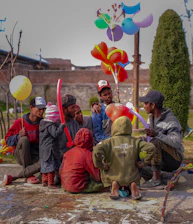 Colorful children's party with balloons and happy kids playing outdoors.