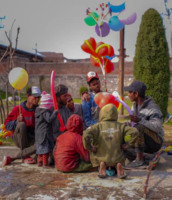 Colorful children's party with balloons and happy kids playing outdoors.