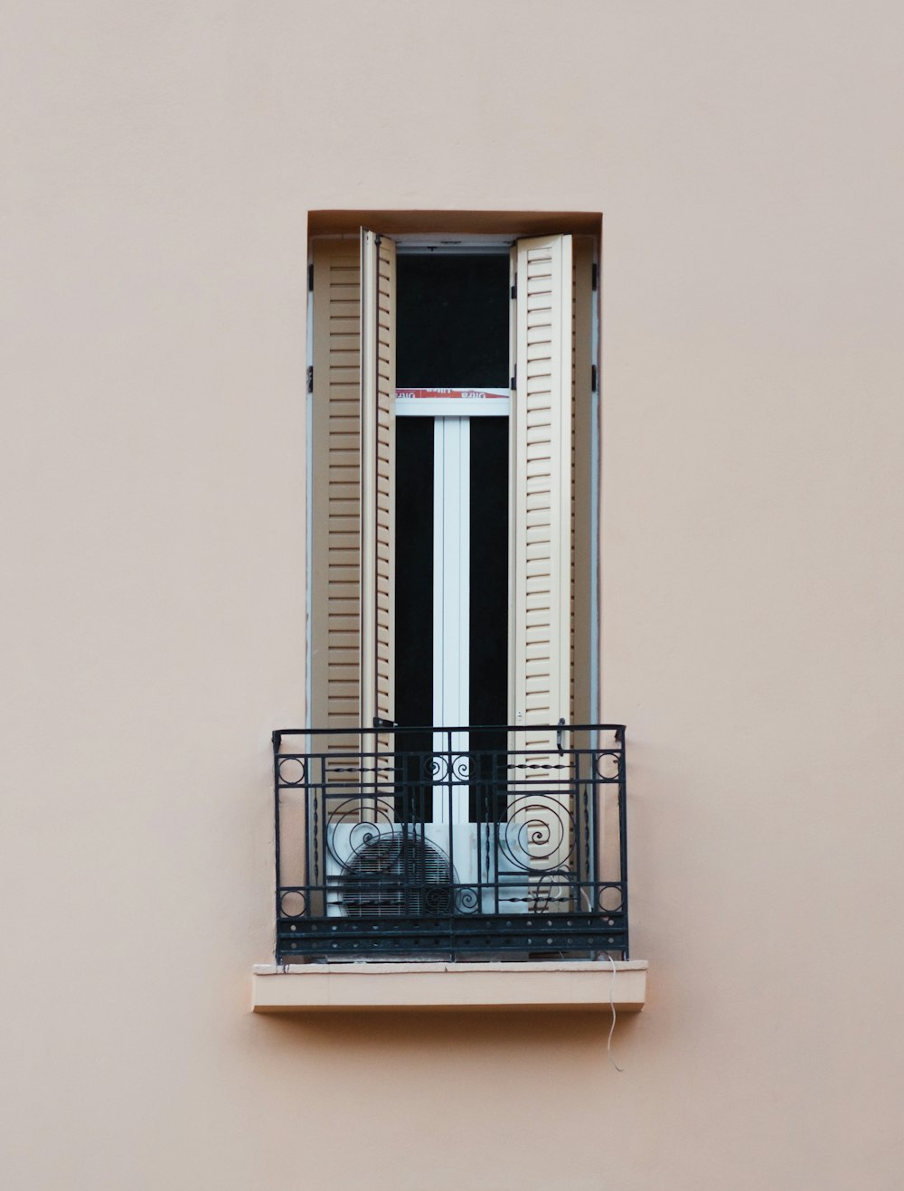 a cat sitting on a balcony looking out the window