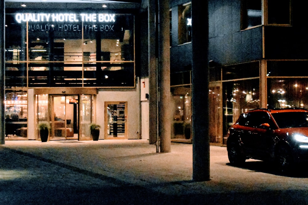 ein Auto, das nachts vor einem Gebäude geparkt ist