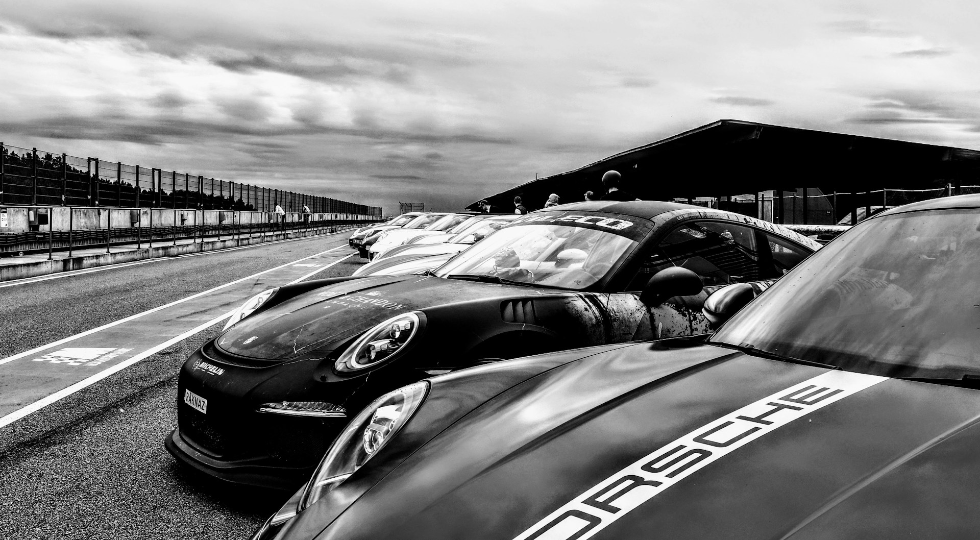 a group of cars parked next to each other on a race track