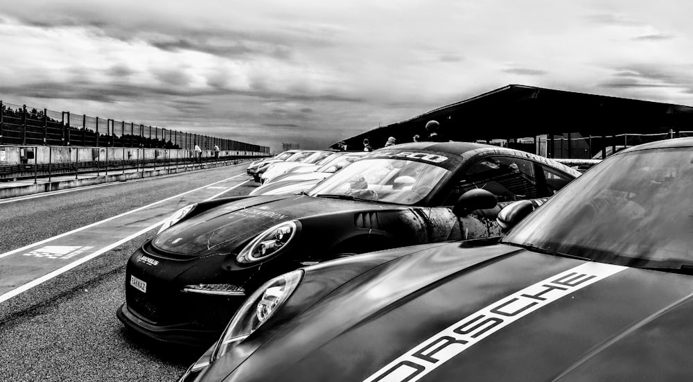 a group of cars parked next to each other on a race track