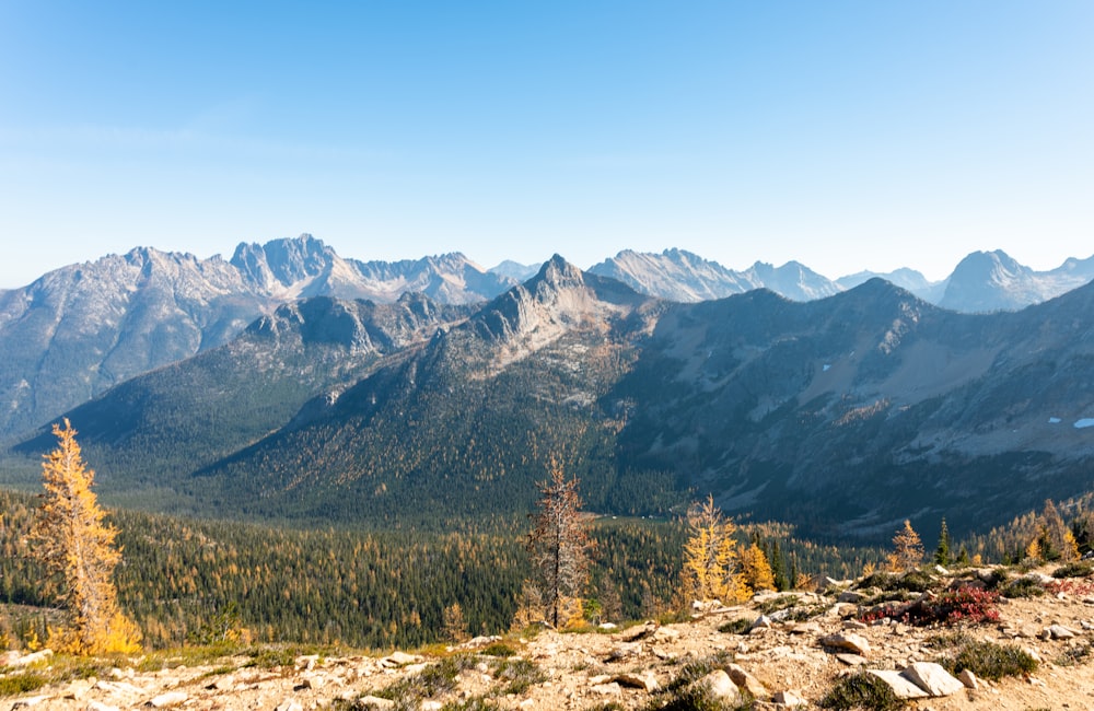 a view of a mountain range with trees and mountains in the background