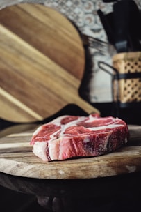 Cuts of red meat displayed on a wooden butcher block.