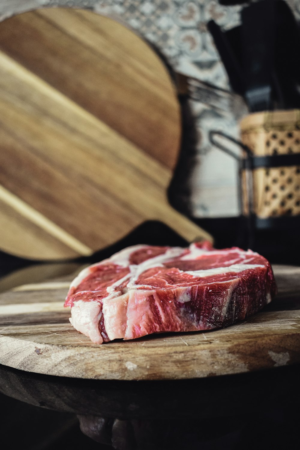 Un trozo de carne sentado encima de una tabla de cortar de madera