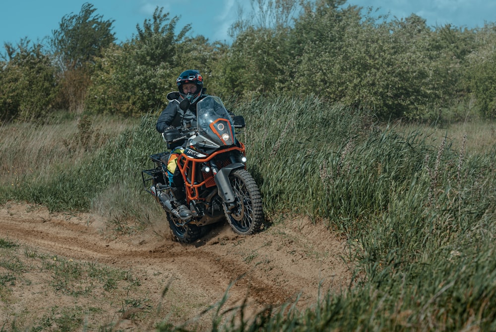 a man riding a motorcycle down a dirt road