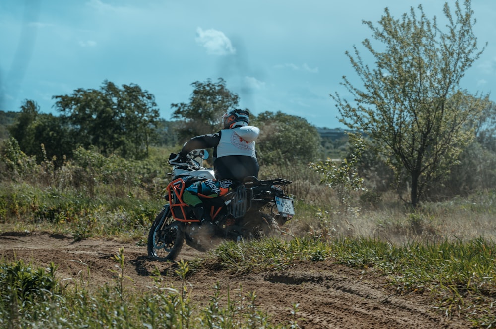 a man riding a dirt bike on a dirt road