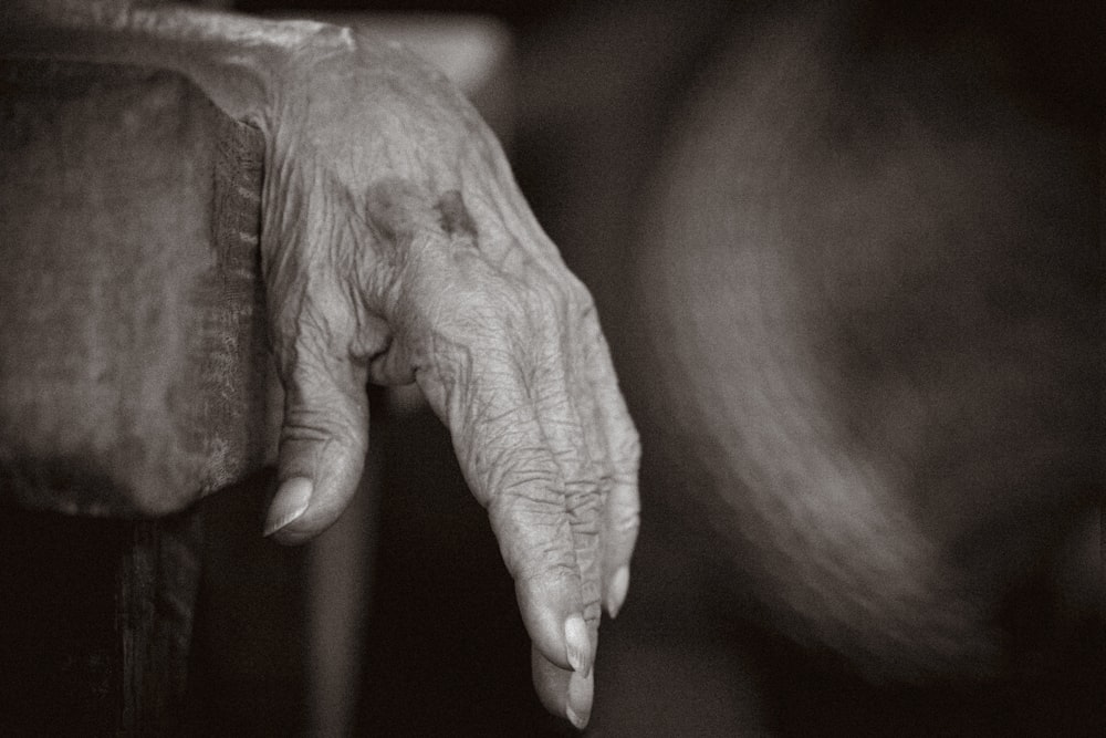 a black and white photo of an old woman's hand