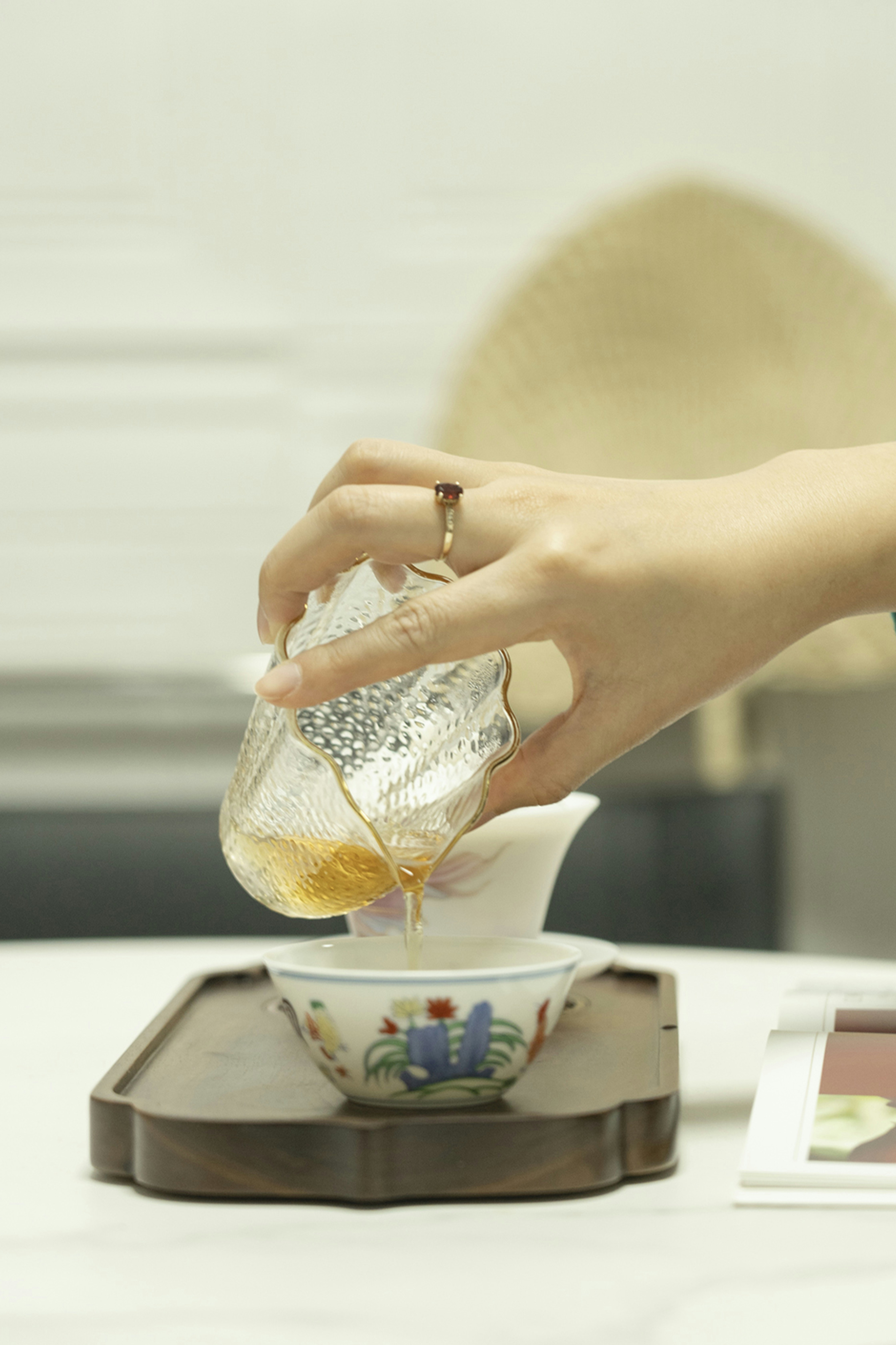 a person pouring tea into a cup on a table