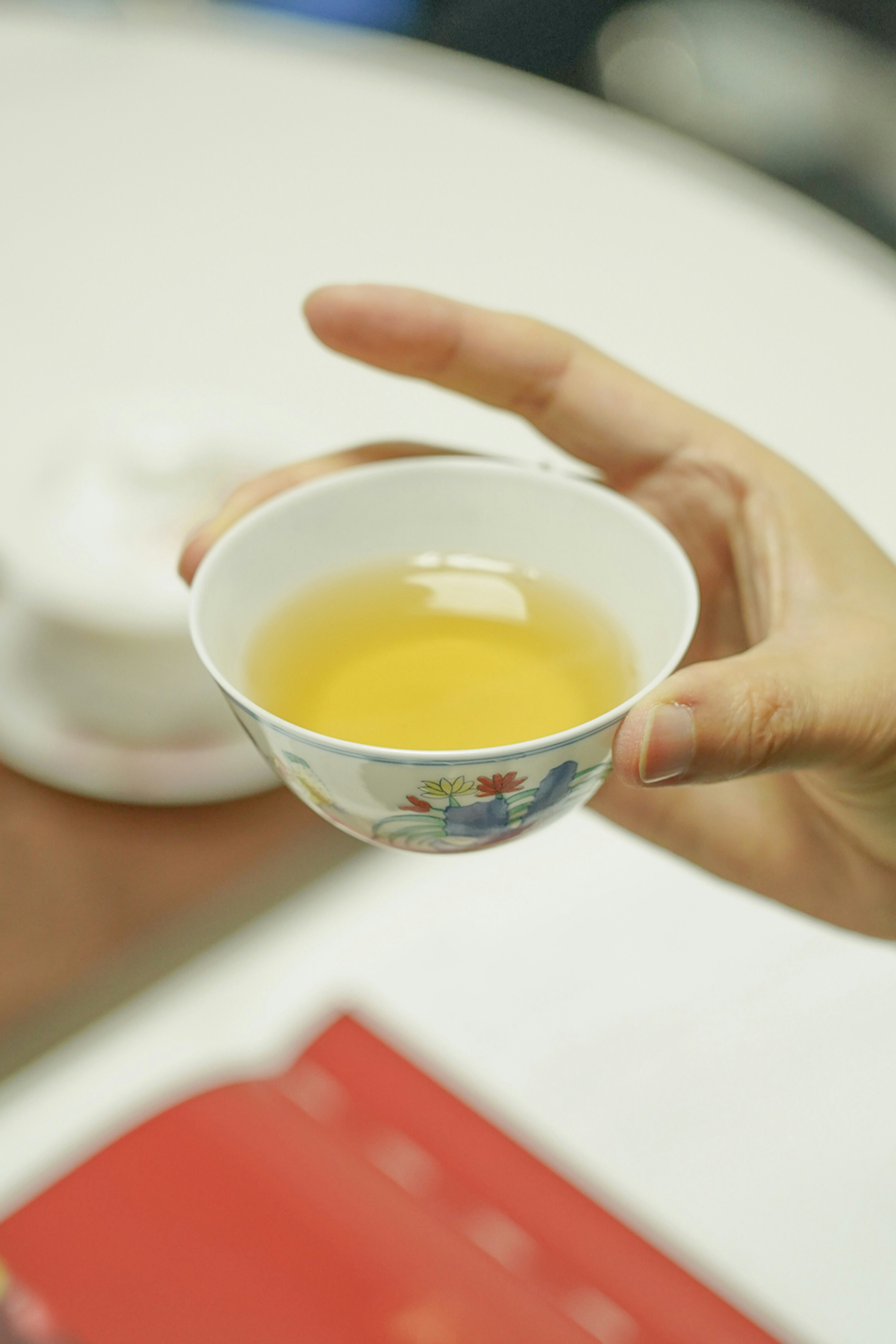 a person holding a cup of tea in their hand