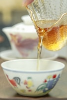 Close-up of traditional Taiwanese tea being poured into a cup during a cultural workshop.