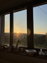 A sunset view from a balcony, casting warm light over a journal and pen.