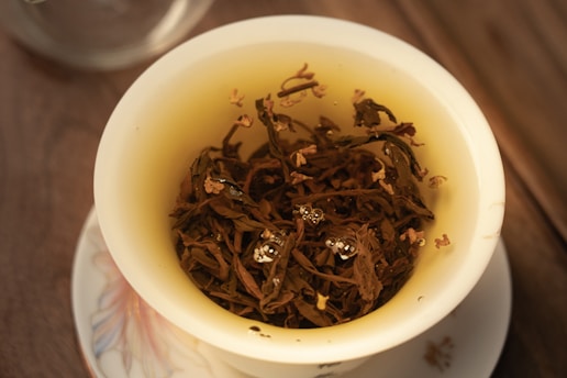 a cup filled with tea sitting on top of a white plate