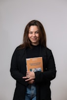 Amara Wisen smiling warmly at a book signing event surrounded by readers.