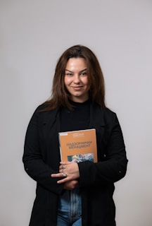Amara Wisen smiling warmly at a book signing event surrounded by readers.