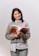 A smiling woman holding the ebook 'Understanding Perimenopause and Its Symptoms'.