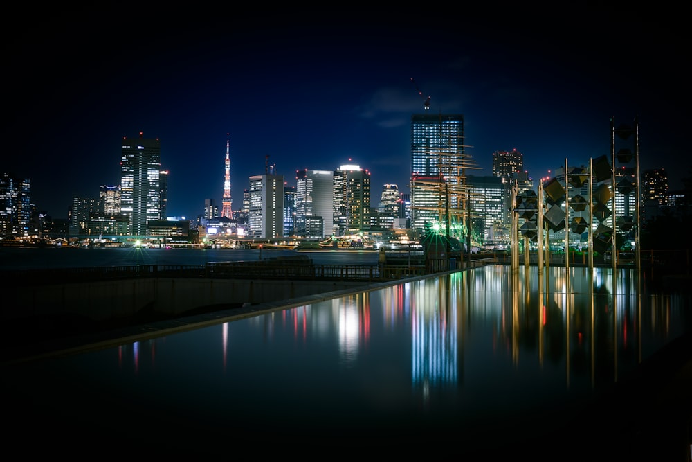 a city skyline at night reflected in a body of water