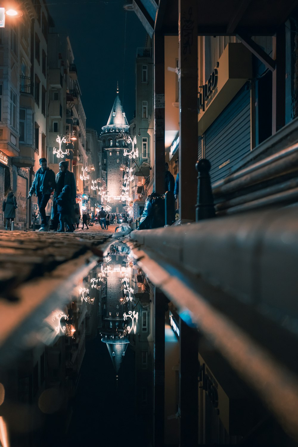 a group of people walking down a street at night