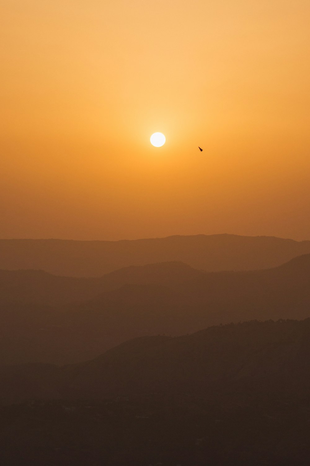 the sun is setting over a mountain range