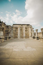 a stone building with columns and a sky background