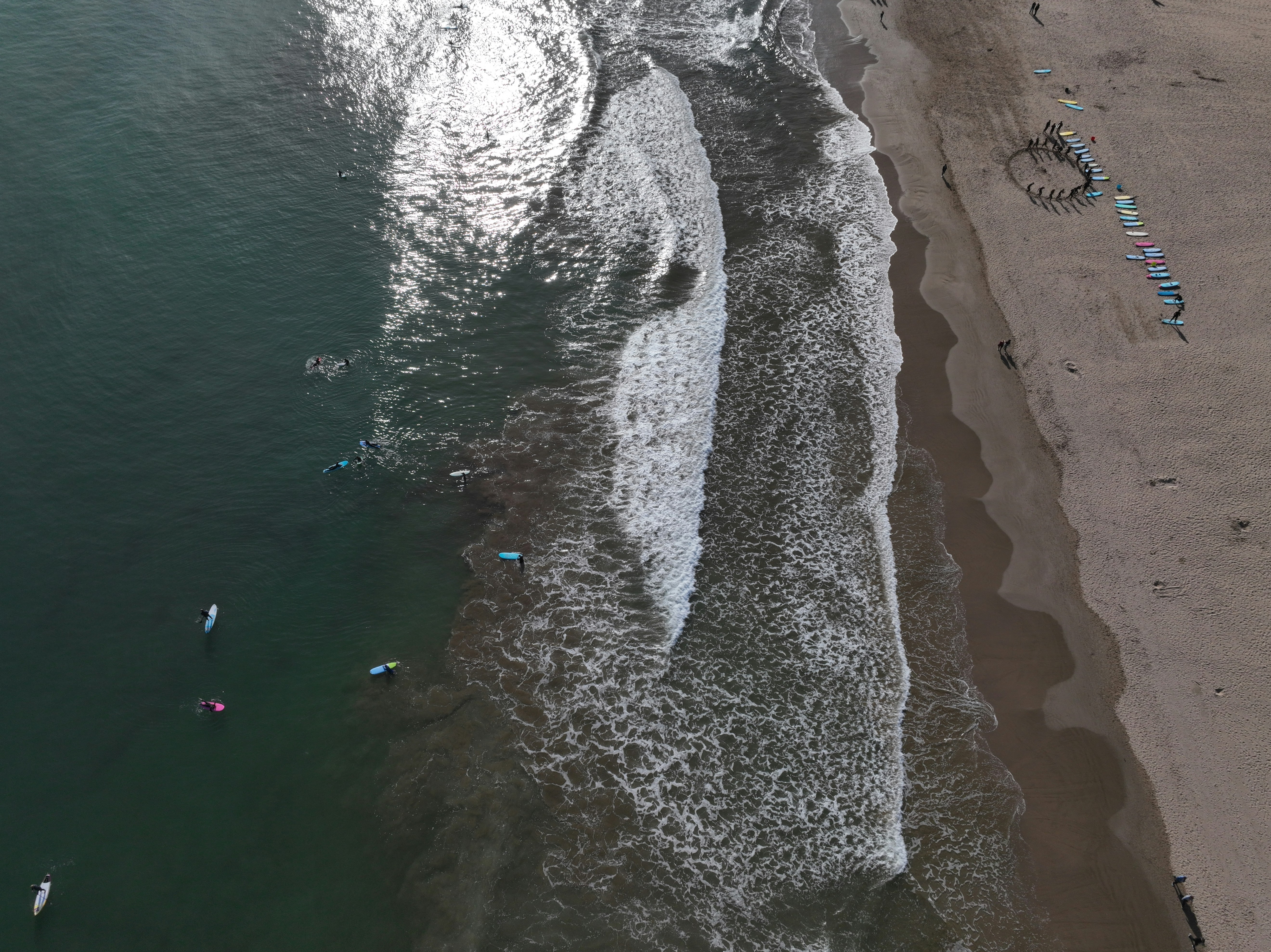 a group of people swimming in the ocean next to a beach