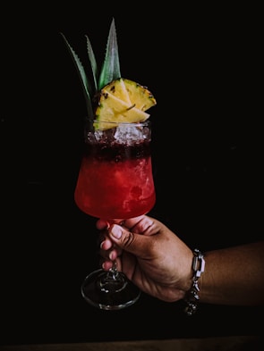 A colorful sorrel cocktail served with tropical fruits.