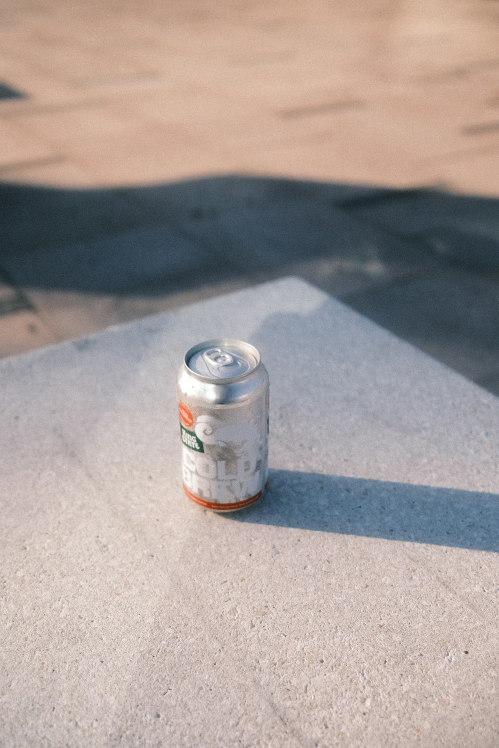 a can of soda sitting on the ground
