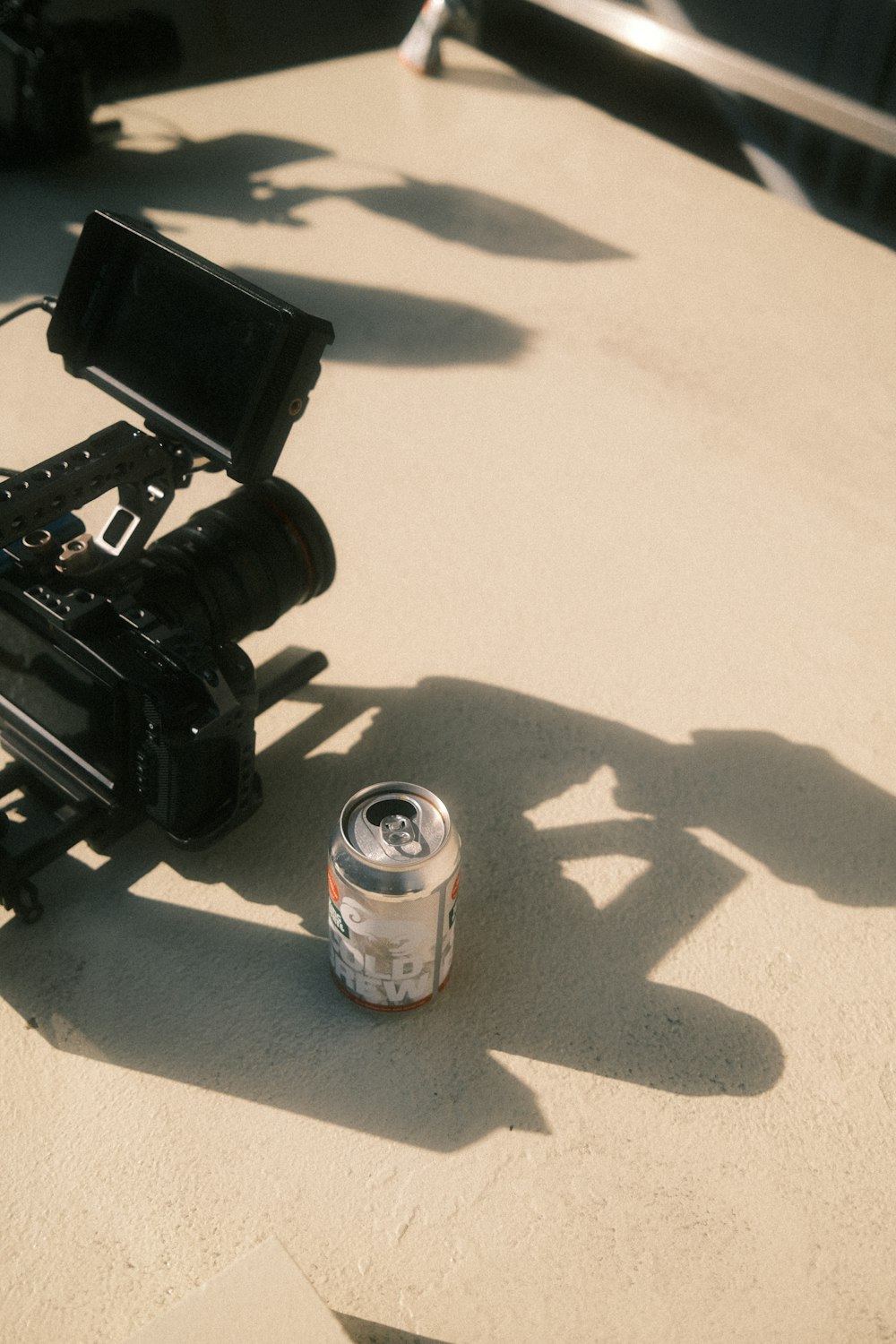 a camera and a can of soda on a table