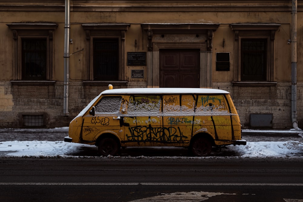 a van covered in graffiti parked on the side of the road