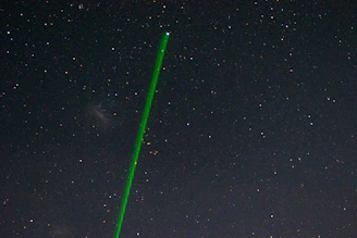 Close-up of the OVR-Guard laser system scanning the sky against a twilight backdrop.