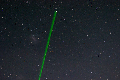 Close-up of the OVR-Guard laser system scanning the sky against a twilight backdrop.