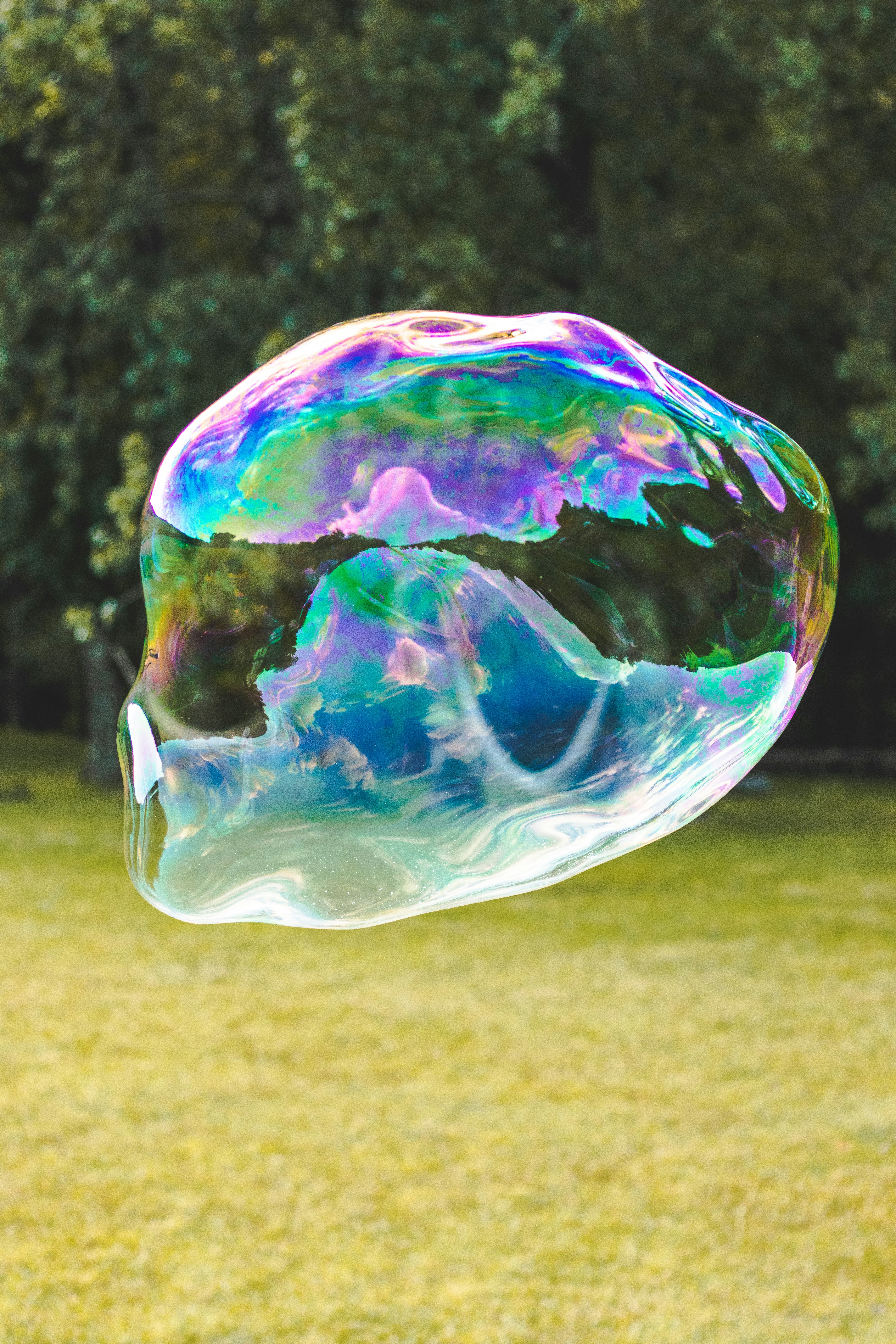 a soap bubble floating in the air over a field
