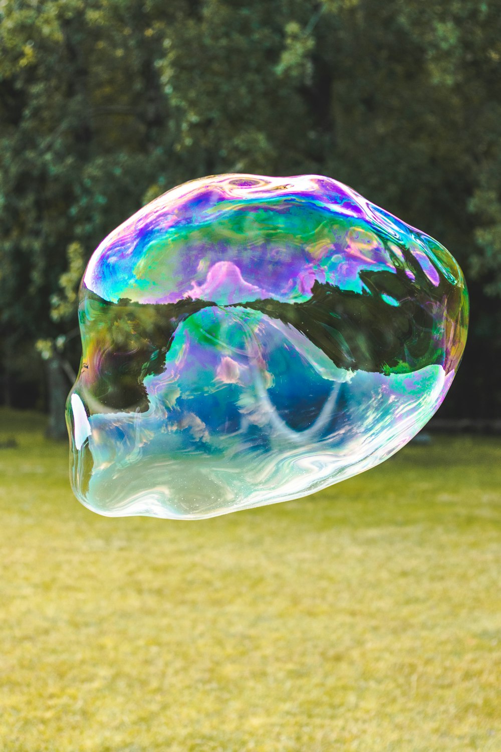 a soap bubble floating in the air over a field