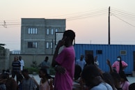 A group of diverse artists sharing ideas during an outdoor film screening event at dusk.