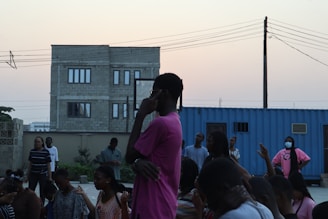 A group of diverse artists sharing ideas during an outdoor film screening event at dusk.