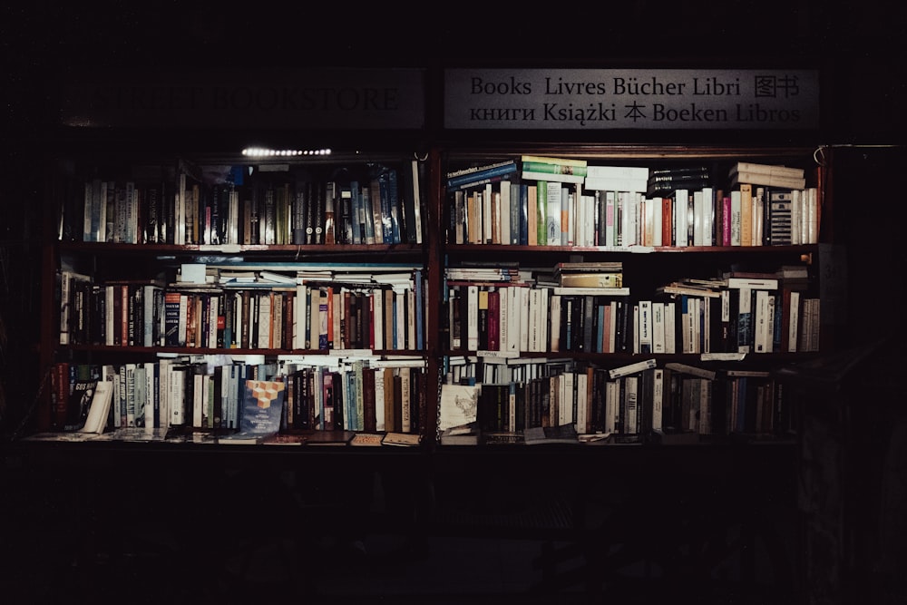 a bookshelf filled with lots of books in a dark room