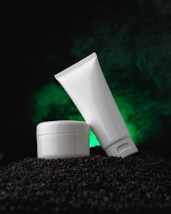 a tube of cream sitting on top of a pile of black rocks