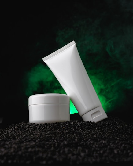 a tube of cream sitting on top of a pile of black rocks