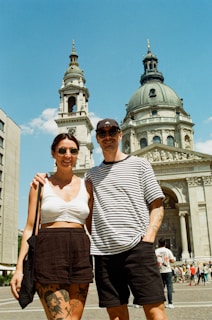 a man and a woman standing in front of a building