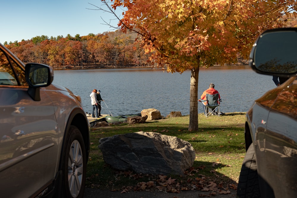 a couple of cars parked next to a lake