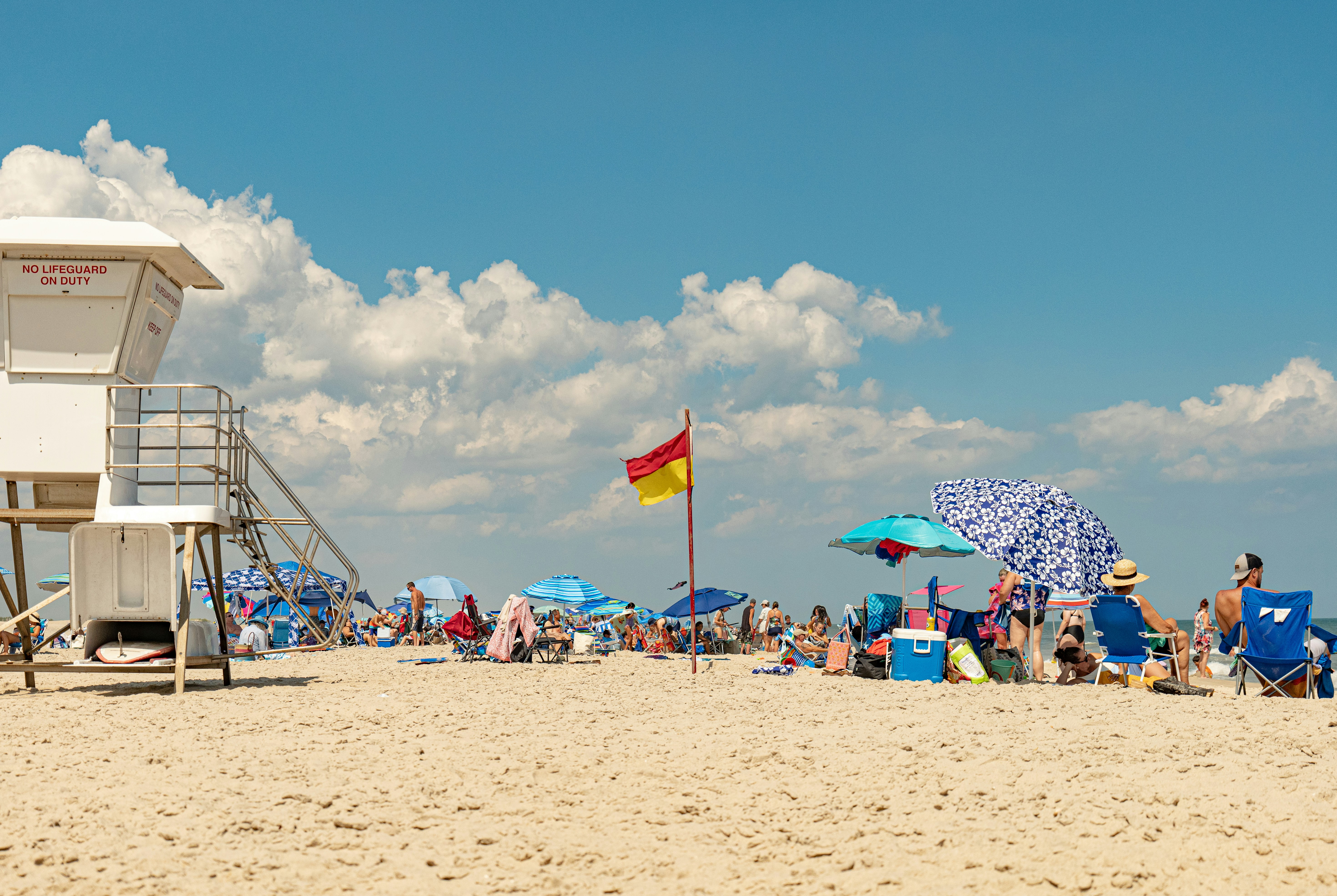 um grupo de pessoas em uma praia com guarda-sóis