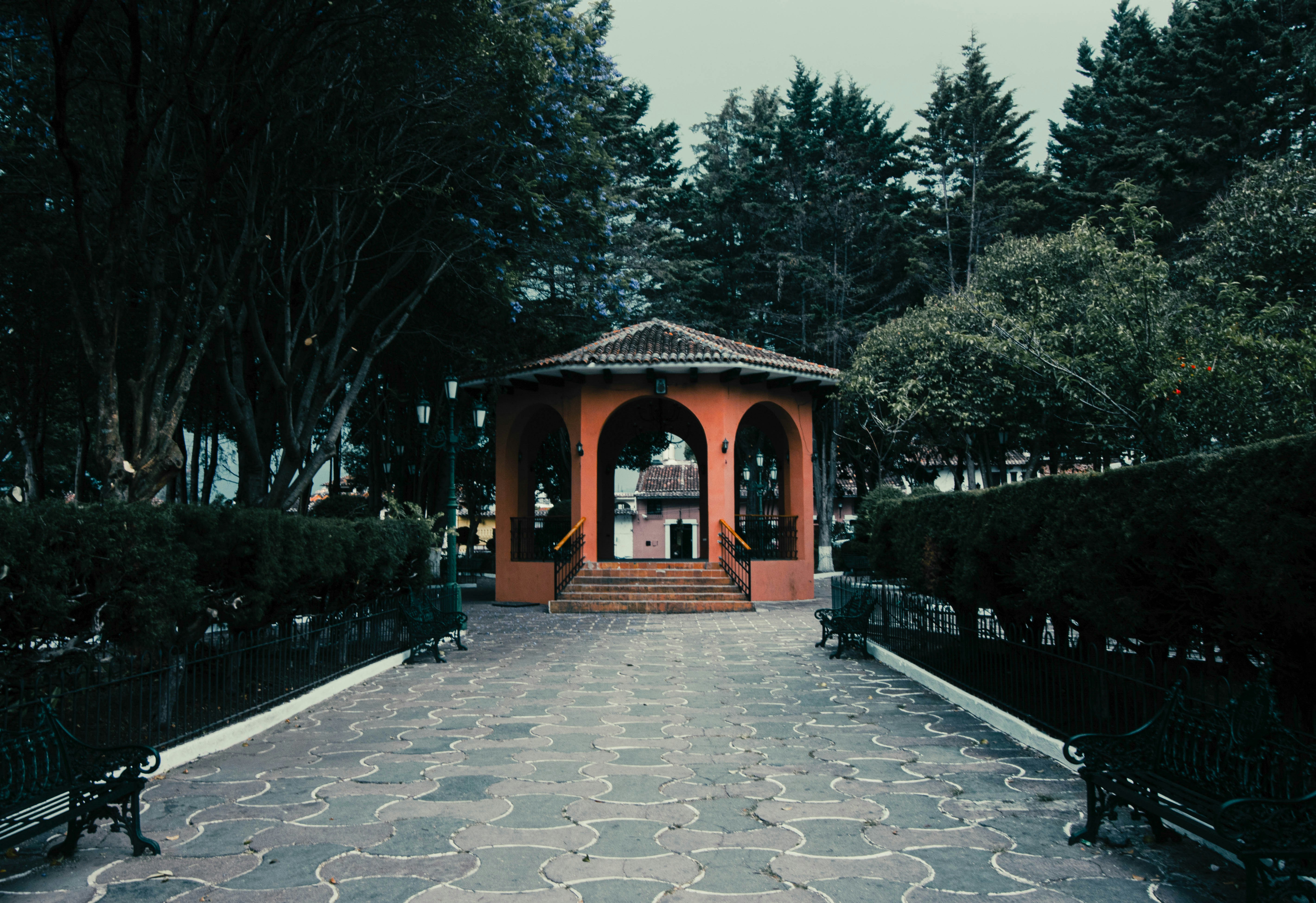 a gazebo in the middle of a park surrounded by trees