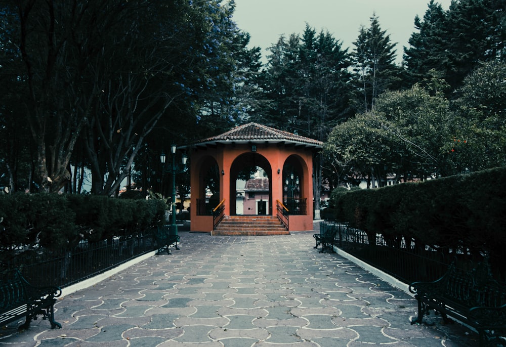 a gazebo in the middle of a park surrounded by trees