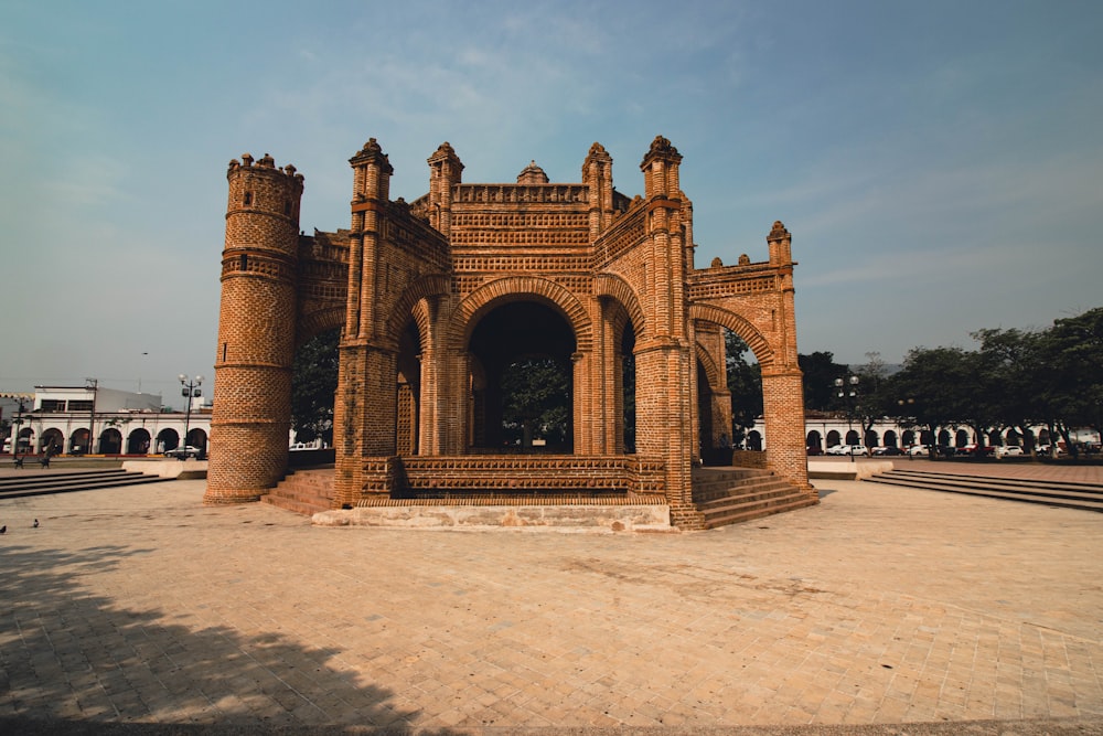 a large brick structure with a clock tower in the background