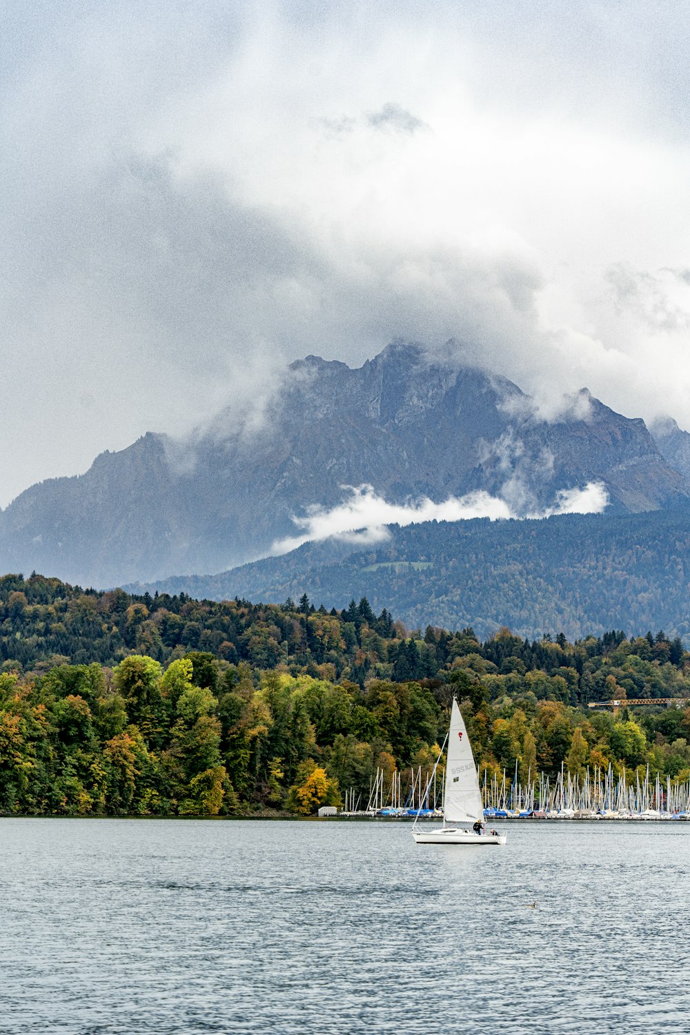 a sailboat on a lake with a mountain in the background