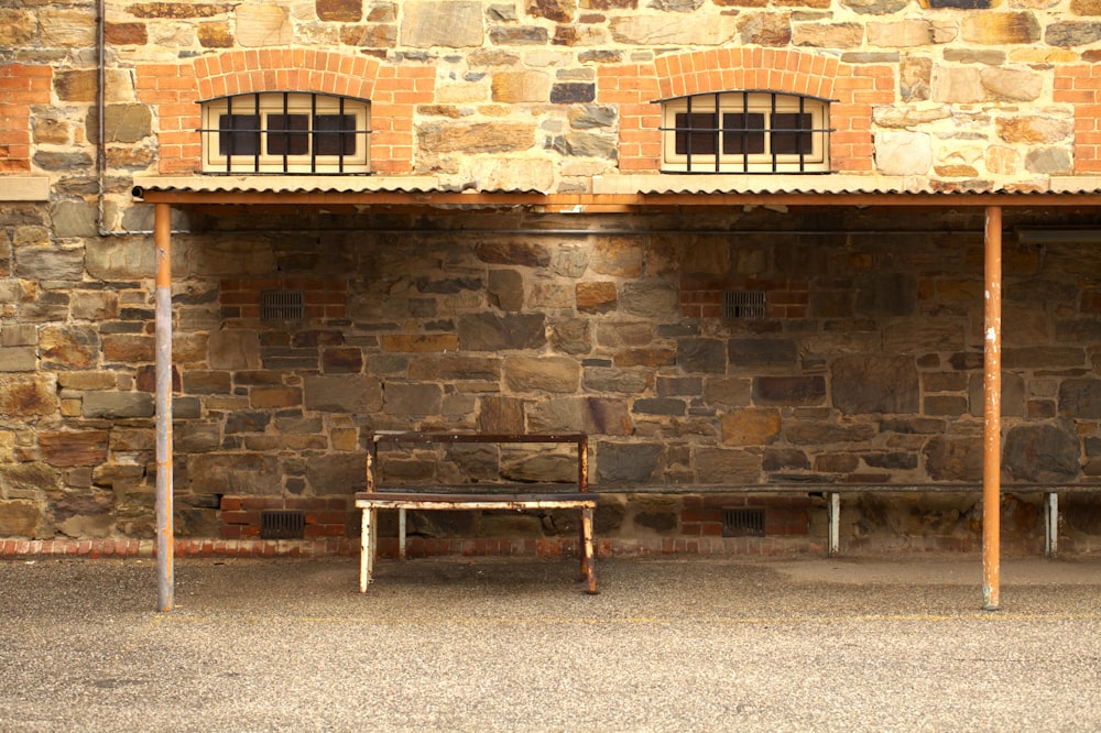 a bench sitting in front of a stone building