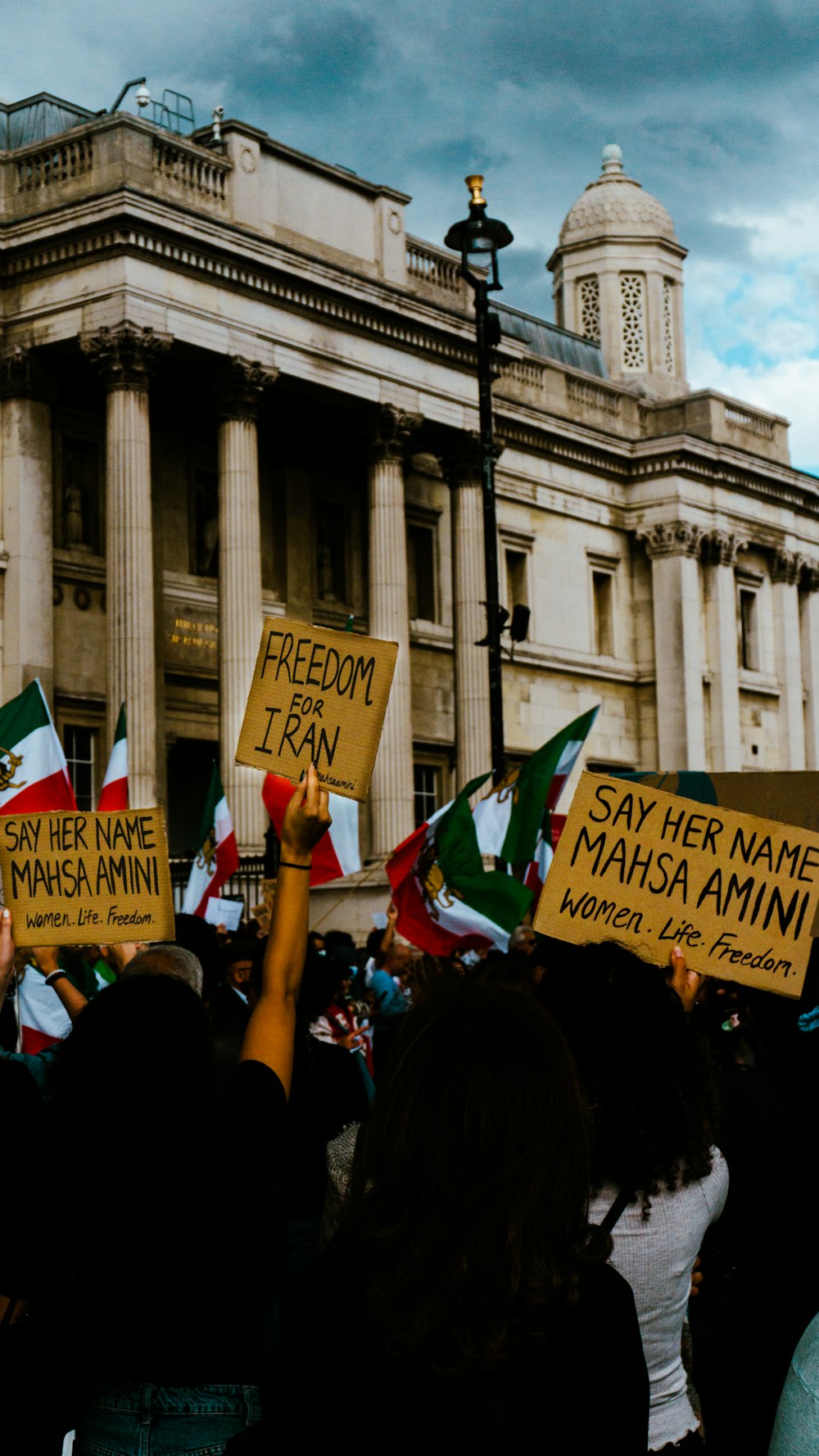 a group of people holding signs in front of a building