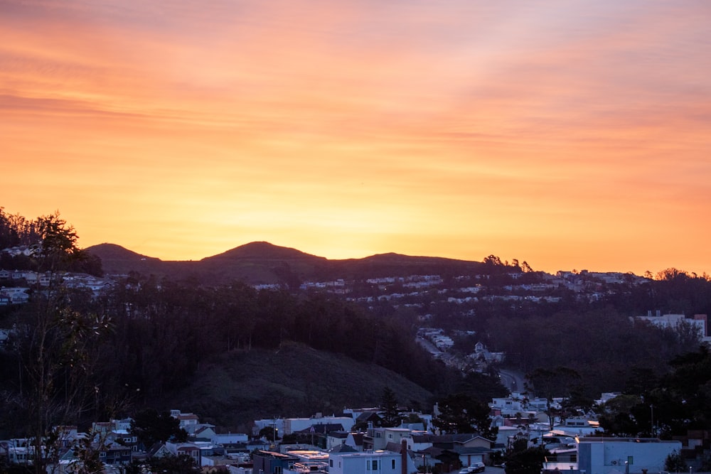 the sun is setting over a small town