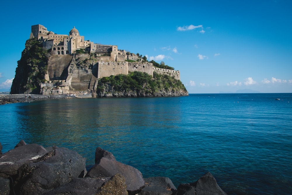 a castle sitting on top of a cliff next to the ocean