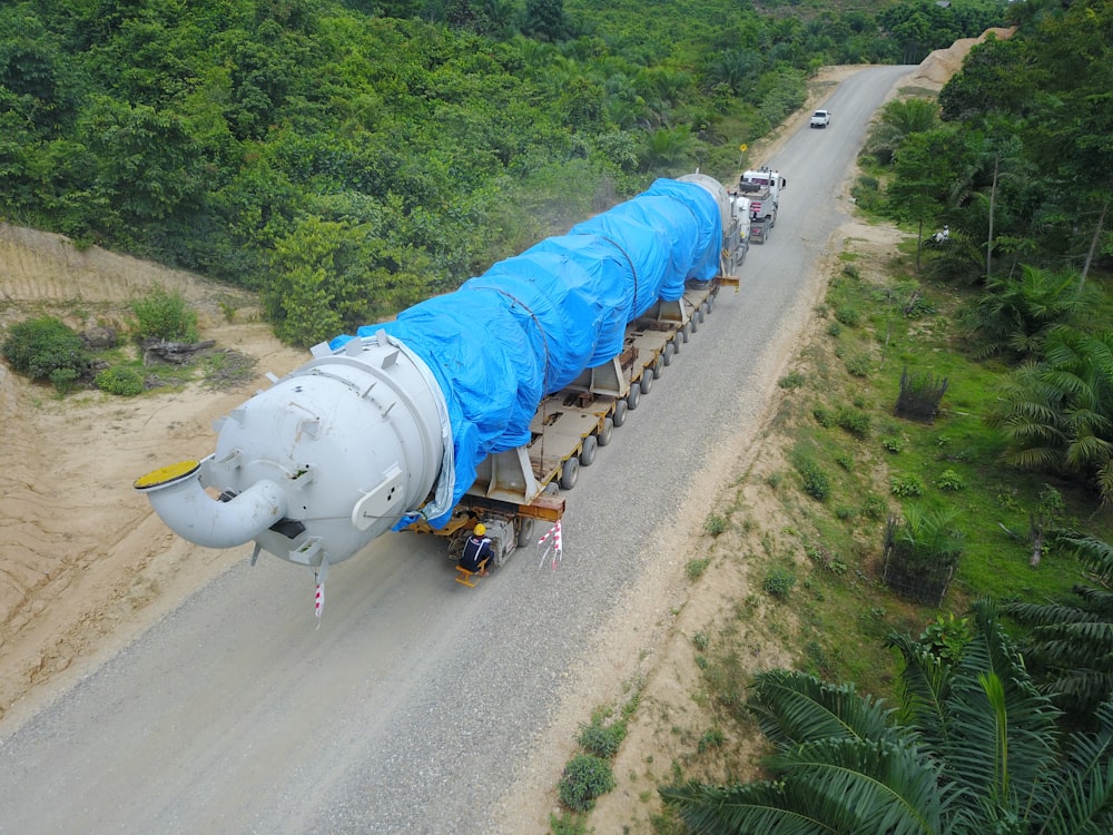 a large truck with a large blue tarp on it's back